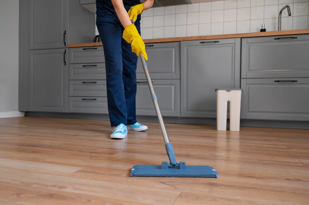 San Francisco maid service employee mopping the floor in a kitchen.